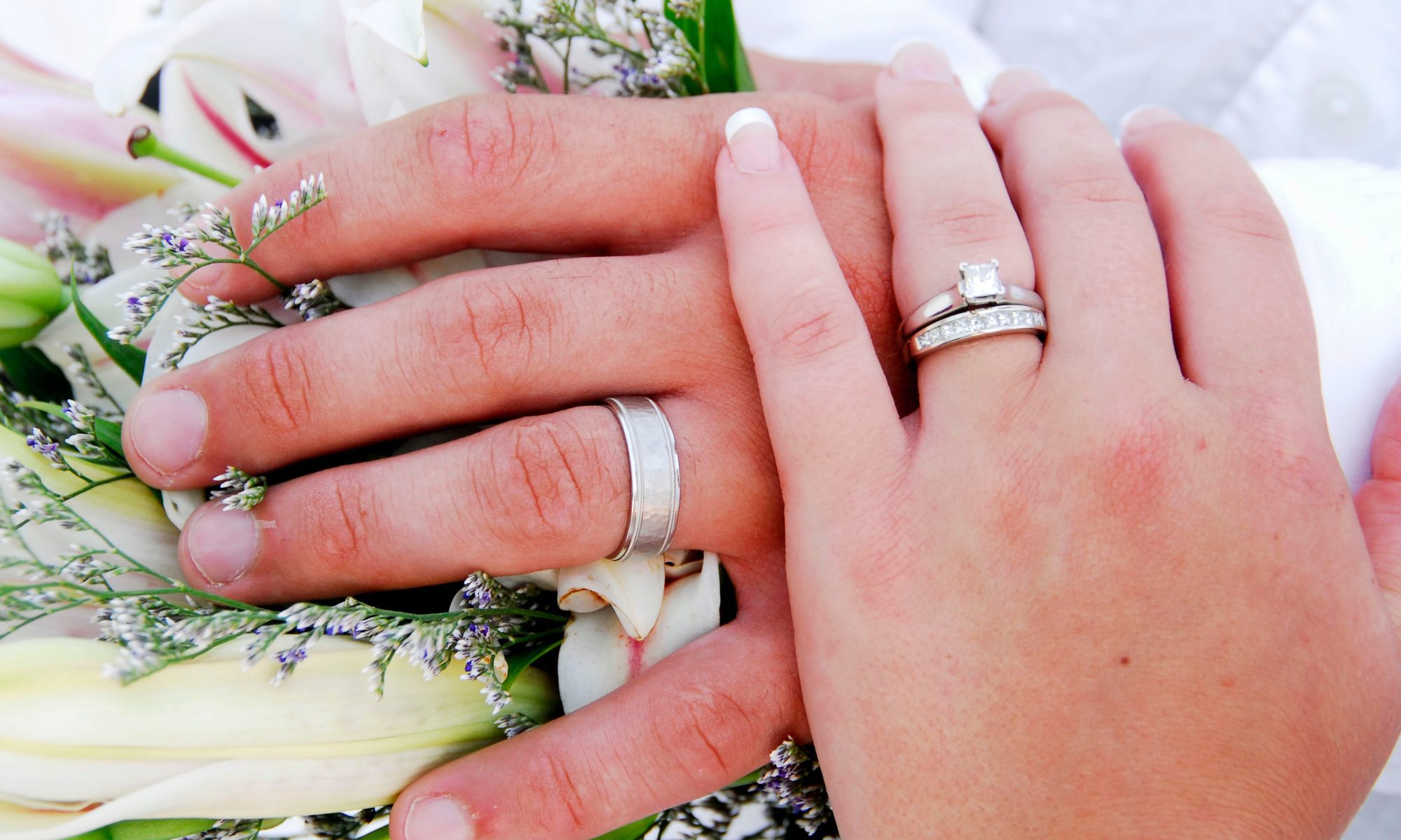 Wedding bands on newly married couple hands examples of Wedding Ring Designer Winfield.